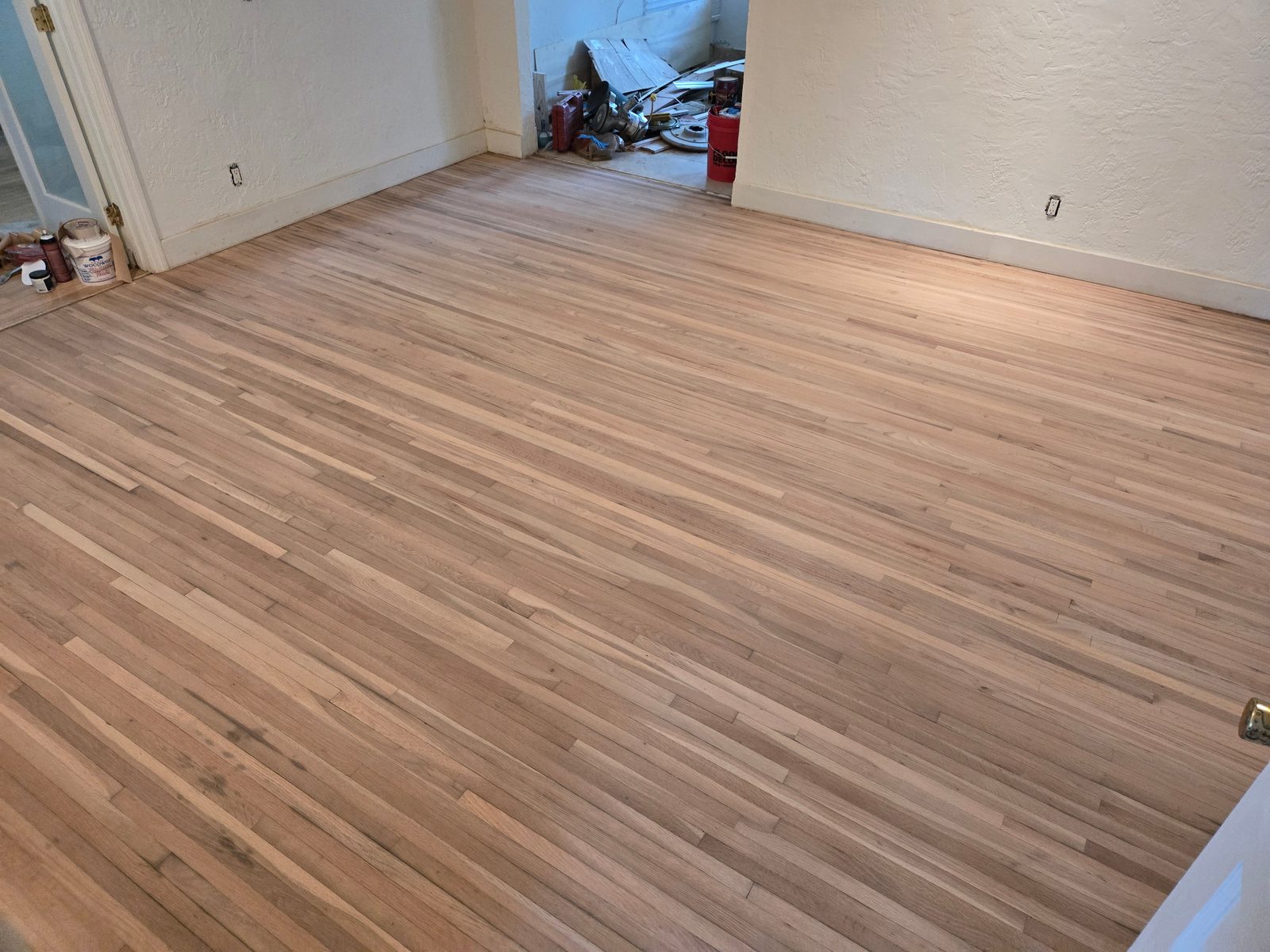 Hardwood floor sanded down to bare wood during preparation in a Hollywood, FL home